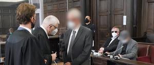 Die beiden angeklagten Ärzte (hinten r und vorne 3.v.l) warten mit ihren Rechtsanwälten Leon Kruse (l), Ulrich Steffen (2.v.l) sowie Lorenz von Geyso (2.v.r) im Sitzungssaal des Landgerichts im Strafjustizgebäude auf den Beginn des Prozesses wegen des Todes eines Kindes nach einer Operation. 