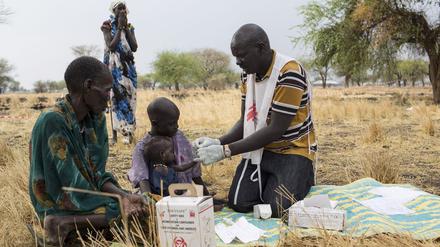 Der medizinische Helfer Gatbel (r) von Medecins Sans Frontieres (MSF) testet am 18.03.2017 in Thaker (Südsudan) ein Kind auf Malaria.