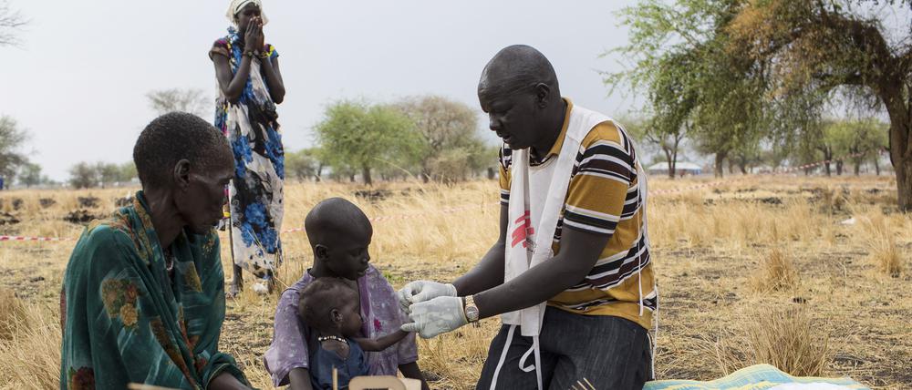 Der medizinische Helfer Gatbel (r) von Medecins Sans Frontieres (MSF) testet am 18.03.2017 in Thaker (Südsudan) ein Kind auf Malaria.