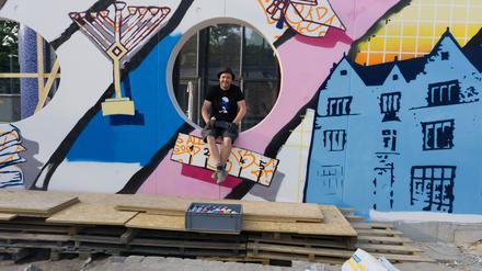 Der Künstler Tobo vor der jüdischen Graffitiwand am Pears Jüdischer Campus