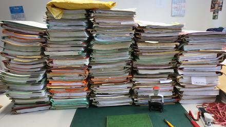 ARCHIV - 14.01.2014, Berlin: SYMBOLFOTO - Stapel mit Akten liegen auf einem Schreibtisch. (zu dpa «Bundeskabinett beschließt Maßnahmenpaket zum Bürokratieabbau» vom 12.12.2018) Foto: Stephanie Pilick/dpa +++ dpa-Bildfunk +++ | Verwendung weltweit