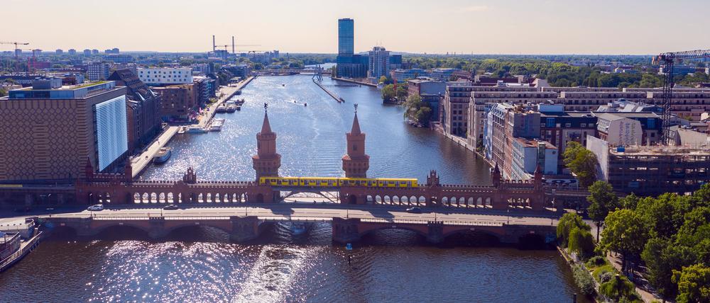 Ein Ausflugsschiff fährt unweit der Oberbaumbrücke auf der Spree in Richtung Innenstadt.