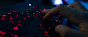 Ein Mann sitzt am Rechner und tippt auf einer Tastatur (Symbolbild).