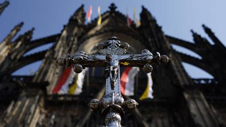 Ein Jesuskreuz mit der Inschrift INRI steht vor Erzbischof Rainer Maria Kardinal Woelki.