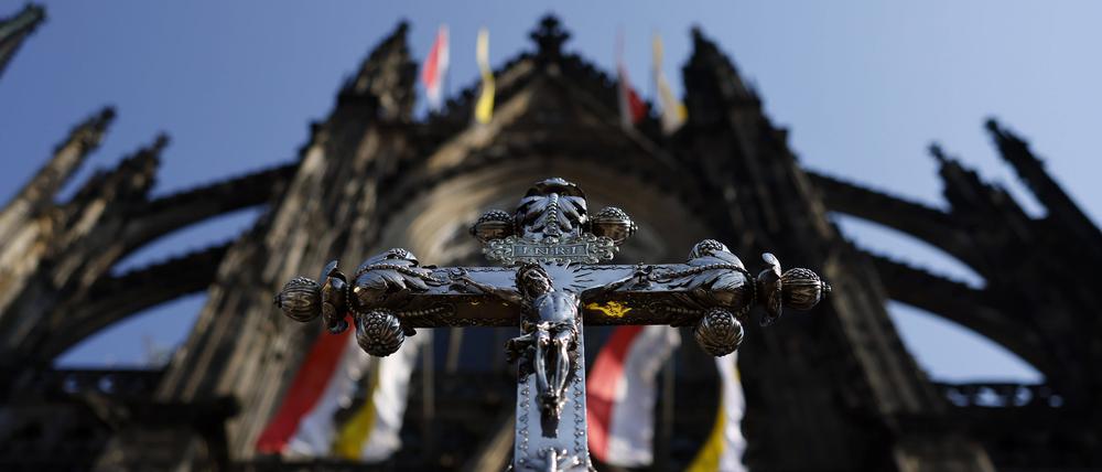 Ein Jesuskreuz mit der Inschrift INRI steht vor Erzbischof Rainer Maria Kardinal Woelki.