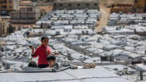 ARCHIV - 13.03.2021, Libanon, Arsal: Syrische Jungen spielen auf dem Dach einer Unterkunft im Flüchtlingslager Barra nordöstlich der libanesischen Hauptstadt Beirut. Syrien befindet sich seit 2011 im Bürgerkrieg, nachdem sich die Syrer inmitten einer Welle von Aufständen des Arabischen Frühlings gegen Präsident Assad erhoben. (zu dpa: "UN warnen vor Syrien-Geberkonferenz vor neuen Flüchtlingsbewegungen") Foto: Marwan Naamani/dpa +++ dpa-Bildfunk +++