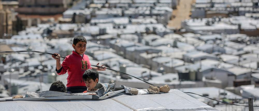 ARCHIV - 13.03.2021, Libanon, Arsal: Syrische Jungen spielen auf dem Dach einer Unterkunft im Flüchtlingslager Barra nordöstlich der libanesischen Hauptstadt Beirut. Syrien befindet sich seit 2011 im Bürgerkrieg, nachdem sich die Syrer inmitten einer Welle von Aufständen des Arabischen Frühlings gegen Präsident Assad erhoben. (zu dpa: "UN warnen vor Syrien-Geberkonferenz vor neuen Flüchtlingsbewegungen") Foto: Marwan Naamani/dpa +++ dpa-Bildfunk +++