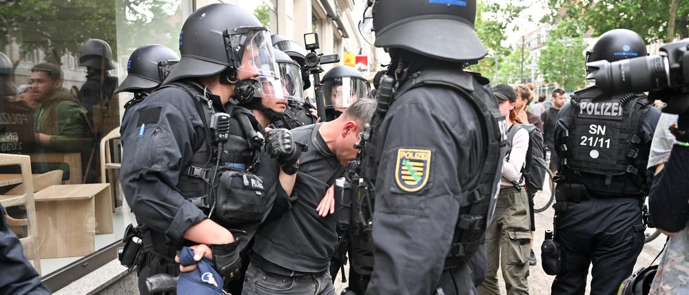 Polizisten halten einen Teilnehmer aus einer Demonstration in Leipzig fest.