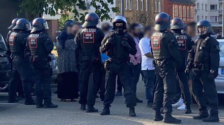 Polizist:innen stehen am Donnerstagabend bei der Massenschlägerei in Castrop-Rauxel und schirmen eine Gruppe von Personen ab.