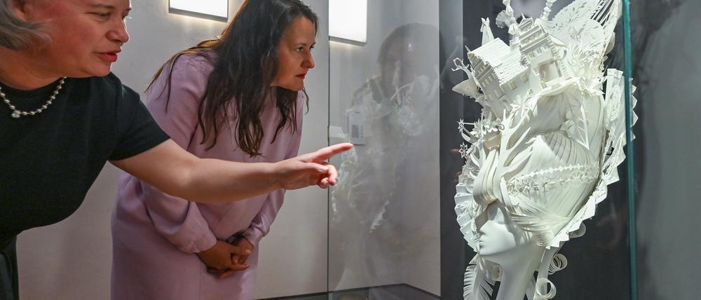 15.06.2023, Brandenburg, Doberlug-Kirchhain: Manja Schüle (2.v.l., SPD), Ministerin für Wissenschaft, Forschung und Kultur des Landes Brandenburg und Babette Weber, Leiterin des Museumsverbunds Elbe-Elster, stehen vor dem Papier-Kunstwerk «Heraldik in Papier» von Asya Kozina (Ukraine) in der Ausstellung zur Sammlung Dohna-Schlobitten im Schloss Doberlug. Die Schau wird offiziell am 18.06.2023 eröffnet.