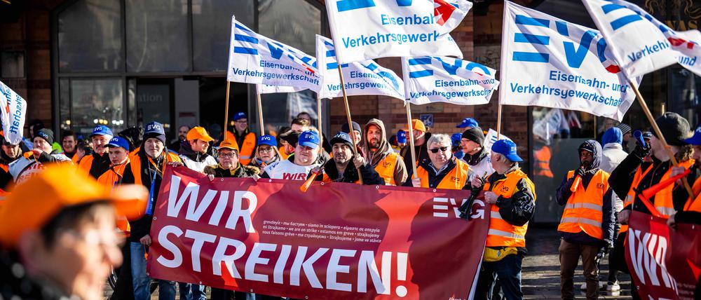 Demonstranten der Eisenbahn- und Verkehrsgewerkschaft (EVG) stehen mit Plakaten vor dem Hauptbahnhof Bremen.