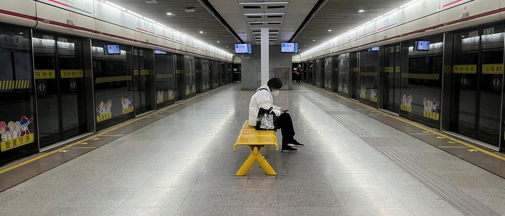 Ein Pendler trägt eine Schutzmaske, während er in einer U-Bahn-Station auf einen Zug wartet. Der Ausbruch der Coronavirus-Krankheit (COVID-19) hält in Shanghai, China, am 20. Dezember 2022 an.