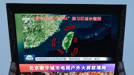 Ein großer Bildschirm in Peking zeigt die Karte von Chinas Militärmanöver bei Taiwan.