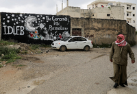 Ein Mann läuft in der syrischen Stadt Binnish an einem Graffiti vorbei.