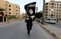 Ein Kämpfer trägt die Flagge des IS im Juni 2014 durch Raqqa.