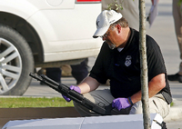 Ein Polizeibeamter in Texas inspiziert eine Waffe, die auf dem Parkplatz in Waco gefunden wurde. Bei der Schießerei zwischen Rockergruppen und der Polizei kamen neun Rocker ums Leben.