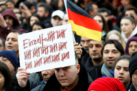 Ein Demonstrant hält in Hanau am Sonntag, 23.2., ein Plakat hoch.