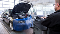Ein Werkstattleiter Marc Oliver Dahl hat einen Diagnose-PC an einen VW Passat TDI angeschlossen.