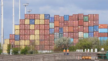 Arbeiter stehen vor Überseecontainer auf einem Terminal im Hafen. Vertreter der EU und Neuseelands haben ein gemeinsames Freihandelsabkommen unterschrieben. 