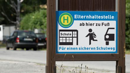 Ein Schild mit der Aufschrift „Elternhaltestelle“ steht auf einem Parkplatz. (Symbolbild)
