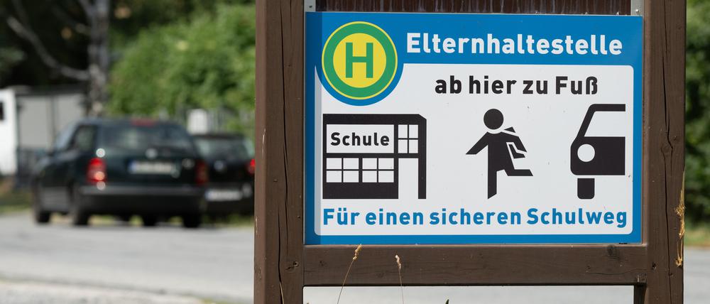 Ein Schild mit der Aufschrift „Elternhaltestelle“ steht auf einem Parkplatz. (Symbolbild)
