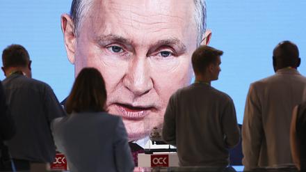 Teilnehmer schauen auf einen Bildschirm, der die Ansprache von Russlands Präsident Putin bei der Plenarsitzung des Russisch-Afrikanischen Wirtschafts- und Humanitären Forums überträgt. 