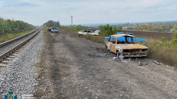 Auf der Straße zwischen Swatowsk und Kupiansk sind zerstörte Autos zu sehen. 
