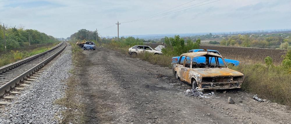 Auf der Straße zwischen Swatowsk und Kupiansk sind zerstörte Autos zu sehen. 