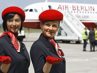 Passagiere warten mit ihrem Gepäck an einem Check-in-Schalter von Air Berlin im Flughafen Tegel in Berlin.