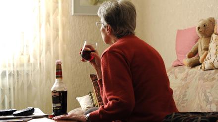 ILLUSTRATION - In der nachgestellten Szene vom 03.04.2012 sitzt eine alte Frau alleine in ihrer Wohnung in Bremen auf dem Sofa und trinkt ein Glas Likör. Der Anteil der Senioren an der Bevölkerung steigt. Doch mit ihren Problemen wie Einsamkeit, Alkoholsucht und Depressionen bleiben sie oft alleine. Foto: Ingo Wagner dpa/lni (Zu dpa-Gespräch "Sucht im Alter kaum zu erkennen" vom 04.04.2012) ++ +++ dpa-Bildfunk +++