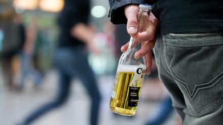 Ein Jugendlicher mit einer Flasche Bier in der Hand.
