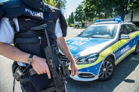 Ein Polizist steht mit seiner Waffe am Montag in Esslingen.