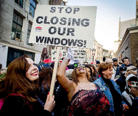"Stop Closing Our Windows!", steht auf diesem Schild einer Demonstrantin. Gemeinsam mit mehr als hundert anderen Menschen demonstriert sie gegen die Schließung von Rotlicht-Fenstern in Amsterdam.