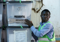 Ein Mitarbeiter der Wahlkommission stapelt in Nairobi Kisten mit Stimmzetteln.