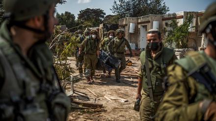 Israelische Streitkräfte bergen Leichen von israelischen Bewohnern aus einem zerstörten Haus. 