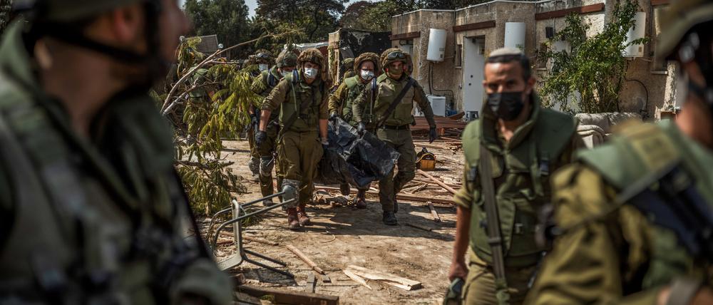 Israelische Streitkräfte bergen Leichen von israelischen Bewohnern aus einem zerstörten Haus. 