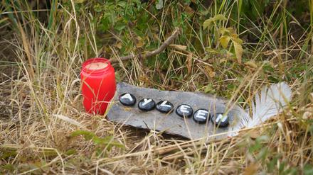 Eine Kerze und eine Tafel mit dem Namen Ayleen liegt am Ufer des Teufelsee im hessischen Wetteraukreis, in dem die Leiche der 14-jährigen Ayleen gefunden wurde. 