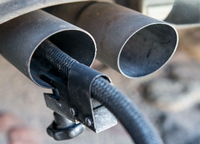 Ein Messschlauch eines Gerätes zur Abgasuntersuchung für Dieselmotoren steckt im Auspuffrohr eines Autos.