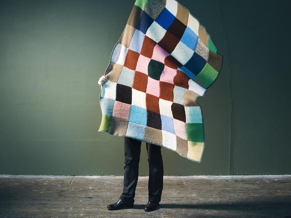 Auch Textilien stellen die beiden Designer her, wie hier eine Patchworkdecke aus vielen Wollquadraten.