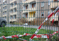 Absperrband der Polizei hängt an einem Zaun vor einer Asylbewerberunterkunft in Chemnitz (Sachsen).
