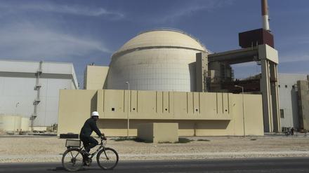 Ein Arbeiter fährt mit seinem Fahrrad vor dem Reaktorgebäude am iranischen Atomkraftwerk Buschehr vorbei (Symbolbild).