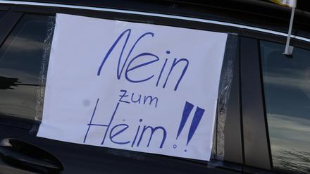 09.12.2023, Thüringen, Gera: Ein Blatt Papier mit der Aufschrift „Nein zum Heim!!“ hängt an einem Auto bei einem Autocorso durch die Innenstadt.