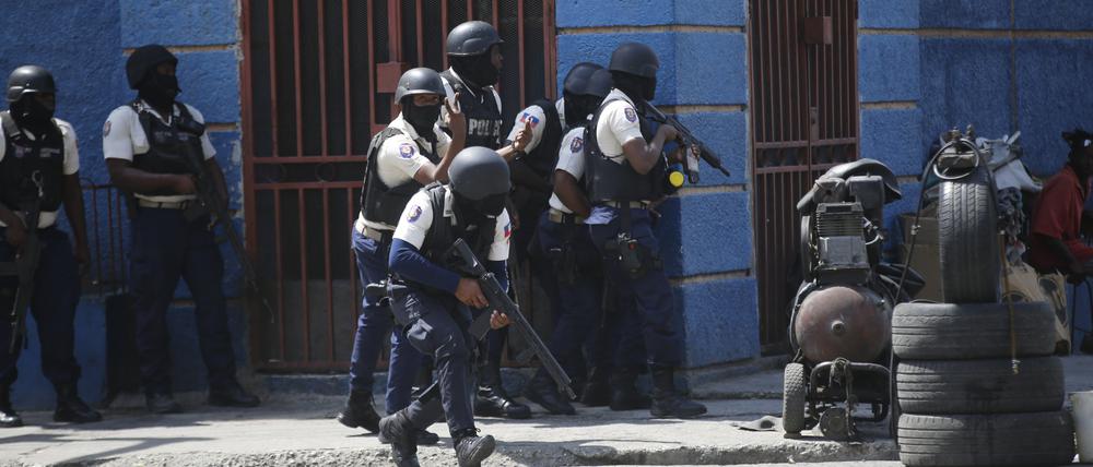Polizisten gehen während einer Anti-Gang-Operation im Viertel Lalue in Port-au-Prince, Haiti, in Deckung.