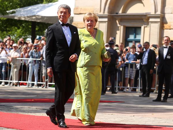 Angela Merkel, ehemalige Bundeskanzlerin, und Ehemann Joachim Sauer kommen zu der Eröffnung der Bayreuther Richard-Wagner-Festspiele im Festspielhaus auf dem Grünen Hügel. Auch 2023 will Merkel wieder nach Bayreuth kommen. 