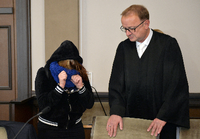 Die Angeklagte und ihr Anwalt Jochen Zersin stehen am Dienstag im Landgericht in Verden (Niedersachsen) im Verhandlungssaal. Weil sie sich nicht um eine sterbende Frau gekümmert haben, stehen seit Dienstag der Ehemann und die Tochter der 49-Jährigen wegen Mordes vor Gericht. Die Staatsanwaltschaft wirft ihnen Mord durch Unterlassen vor.