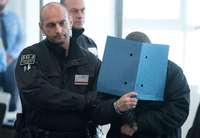 Ein Angeklagter wird am ersten Prozesstag in den Verhandlungssaal in Dresden geführt.