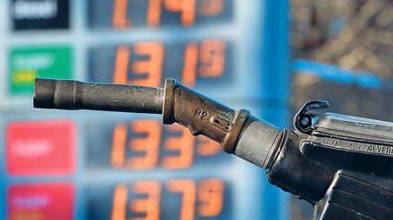 Hinter einer Zapfpistole sind am 11.11.2015 an einer Tankstelle in Kaufbeuren (Bayern) Benzinpreise zu sehen.