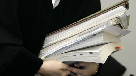 Eine Richterin trägt Bücher und Akten zu einer Verhandlung des Sozialgerichts in der Berliner Invalidenstraße.