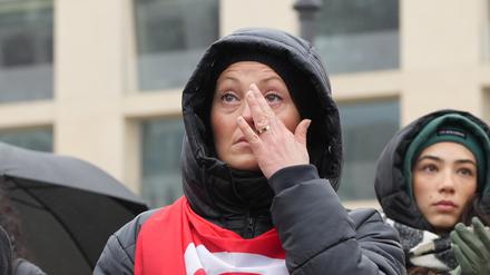 Eine Frau weint bei einer Gedenkveranstaltung zum Gedenken an die Opfer der Erdbeben in der Türkei und Syrien vor dem Brandenburger Tor in Berlin.