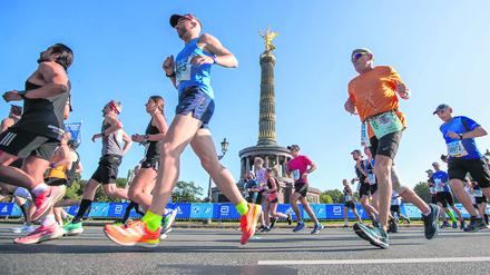 Läufer passieren beim Berlin-Marathon 2021 auf der Straße des 17. Juni die Siegessäule.